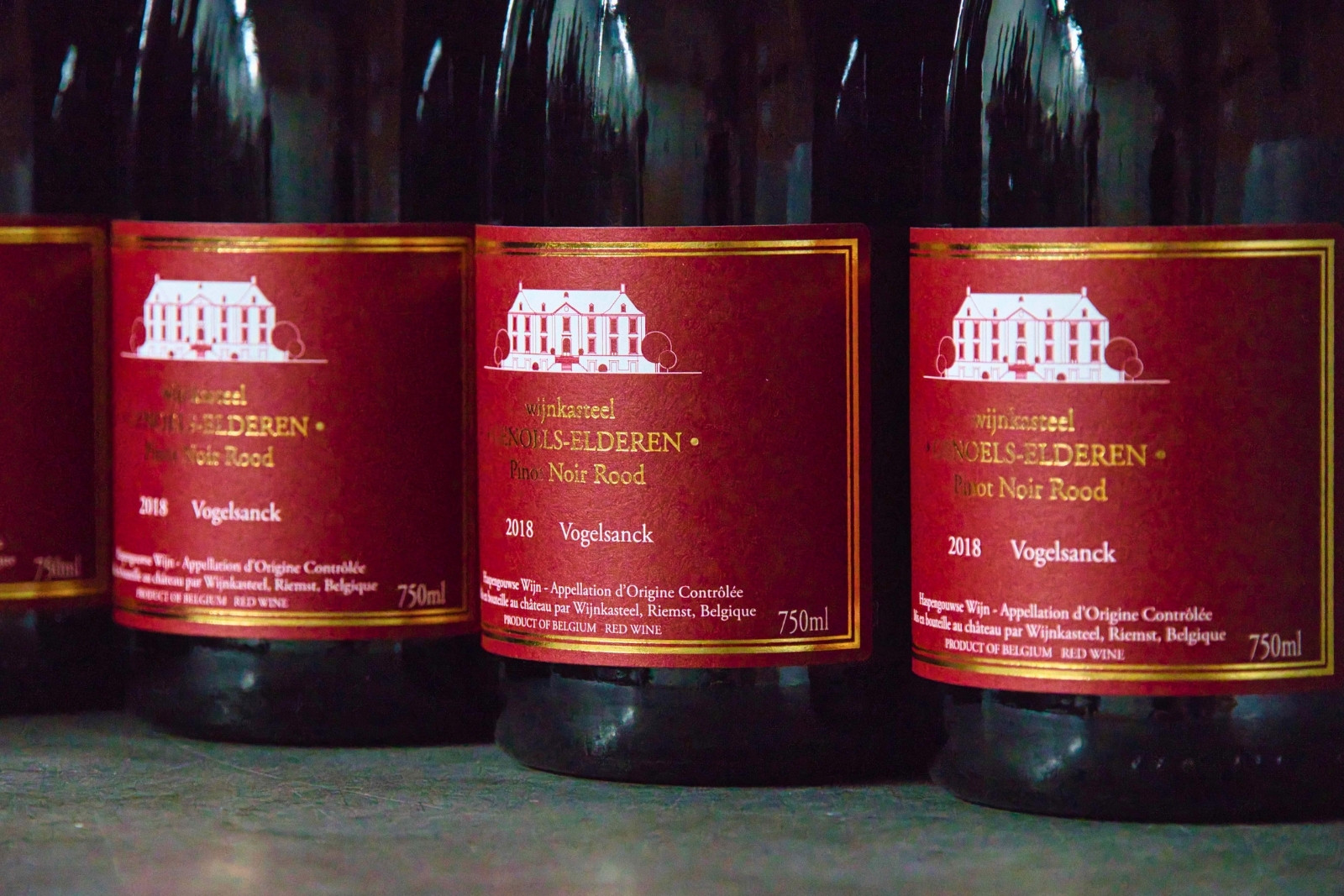 Bottles of Genoelselderen Pinot Noir Rood after just being sealed with wax