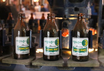 Oude bierflesjes staan tentoongesteld in het restaurant van Brouwerij De Halve Maan